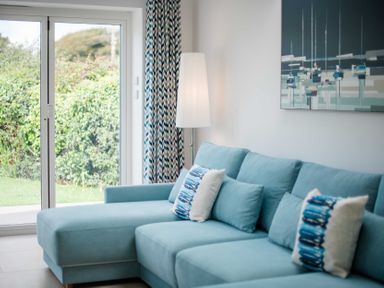 A living room with a sofa and lamp at Lanesend in St Agnes
