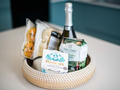 A basket with a bottle of sparkling wine and baked goods at Lanesend St Agnes