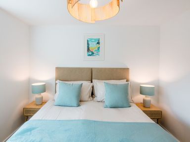 A bedroom with a bed and bedside lamps at Lanesend in St Agnes