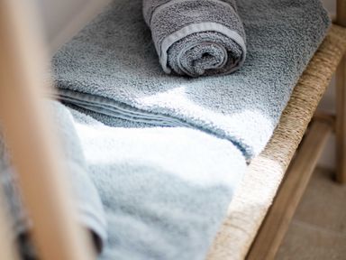 A shelf with folded and rolled towels at Lanesend in St Agnes