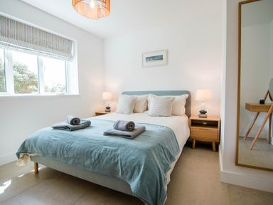 A bedroom with a bed and bedside tables at Lanesend in St Agnes