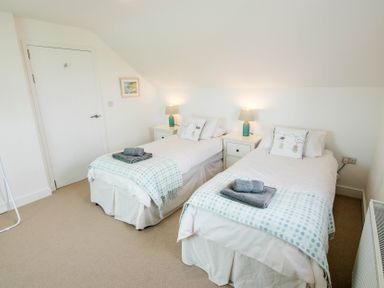 A bedroom with two single beds and a nightstand at Lanesend in St Agnes