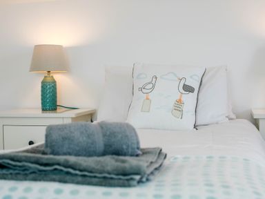 A bedroom with a lamp and decorative pillow at Lanesend in St Agnes