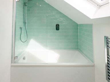 A bathroom with a bathtub and shower area at Lanesend St Agnes
