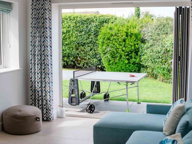 A living room with a table tennis table and sofa at Lanesend in St Agnes