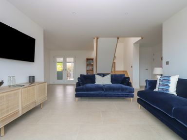 A living room with a television and sofas at Lanesend in St Agnes