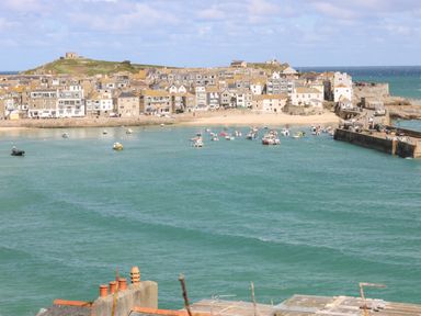 A coastal town with houses near a beach and boats in the water at Gurnard's Cottage in St Ives