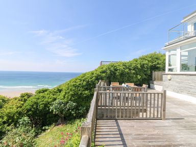 A wooden deck with outdoor furniture and ocean view at St Ives View in Porthtowan
