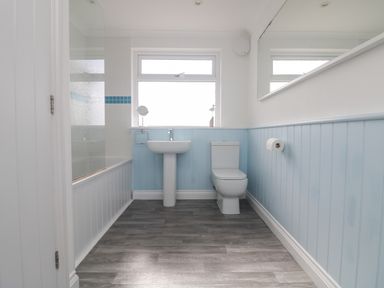 A bathroom with a bathtub shower sink toilet and mirror at St Ives View in Porthtowan