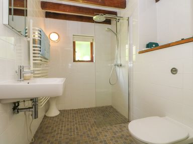A bathroom with a sink a towel rack a walk-in shower and a toilet at Oaklands Near Boscastle