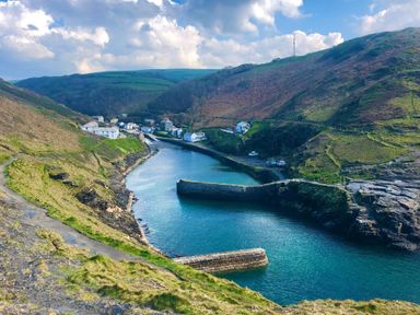 A small harbor with water surrounded by hills and houses near Boscastle