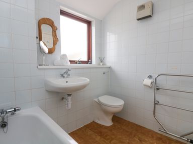 A bathroom with a sink toilet bathtub and a window at Lookout in Falmouth