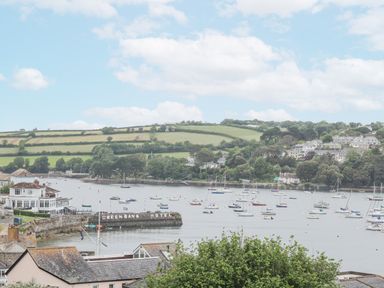 A harbor with boats on the water and green hills in the background at Lookout in Falmouth
