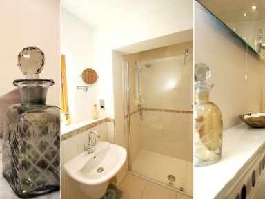 A bathroom with a glass bottle on a counter a sink and a shower with a glass door at Totherside in Kingswear