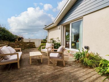 A patio with seating and plants at Seaport Lodge Mawgan Porth