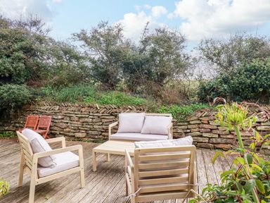 An outdoor seating area with a table and chairs at Seaport Lodge Mawgan Porth