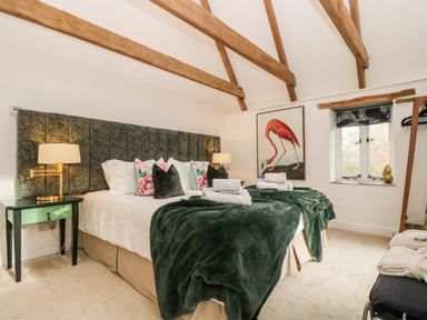A bedroom with a double bed pillows and bedside tables with lamps at Lost Barn Watergate Bay