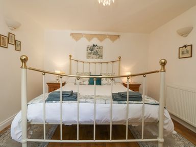 A bedroom with a metal framed bed and bedside tables with lamps at Courtyard Nancegollan nr Porthleven