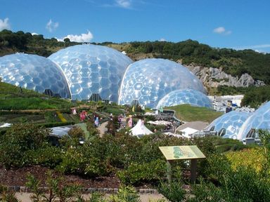 Outdoor view of large geodesic domes with plants and walkways in front at Higher Kernick Stable Helland near Blisland