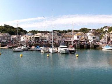 A harbor with boats docked in the water and buildings along the shore at The Old Dairy in Padstow