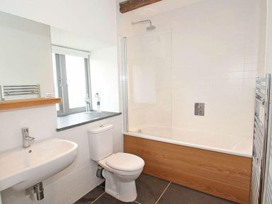 A bathroom with a sink toilet bathtub and a window at The Old Dairy in Padstow