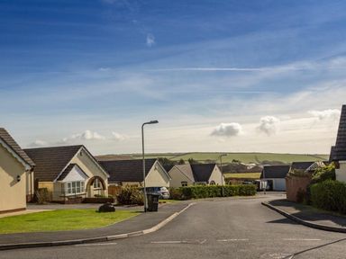 A street with houses a lamp post and cars at Fairways in Woolacombe
