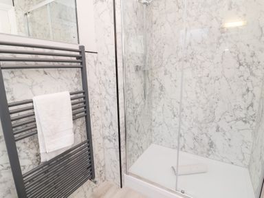 A bathroom with a shower and towel rail at Fairways in Woolacombe