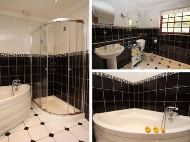 A bathroom with a corner bathtub with rubber ducks a shower enclosure a toilet a pedestal sink and black and white tiled walls and floor at Mengarth in Cadgwith