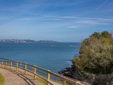A coastal path with a wooden fence overlooking the sea with an island in the distance at Bayview in Brixham