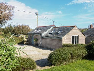 A small stone and wood house with skylights and a gravel driveway surrounded by bushes and trees at Hay Loft Bolenowe Nr Portreath