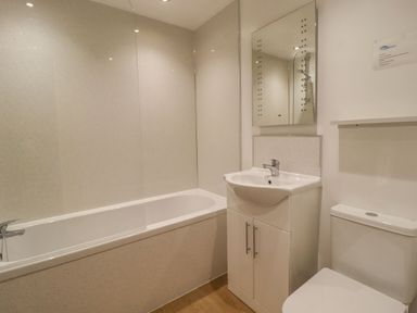 A bathroom with a bathtub shower sink with cabinet mirror and toilet at The Old Hen Shed in Hainworth near Haworth