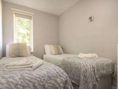 A bedroom with two single beds with patterned blankets and pillows at Valley Lodge 58 in Callington