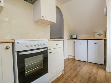 A kitchen with an oven stove toaster two small refrigerators and a bread bin at Valley Lodge 5 Callington