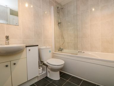 A bathroom with a sink cabinet toilet bathtub and shower at Valley Lodge 5 in Callington