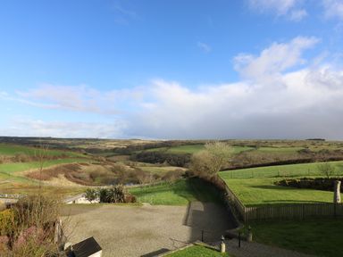 A rural landscape with fields trees and a gravel driveway at Marhayes in Camelford