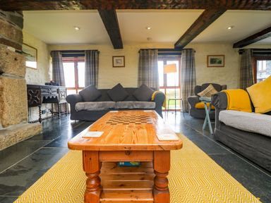 A living room with sofas wooden coffee table and yellow rug at Marhayes in Camelford