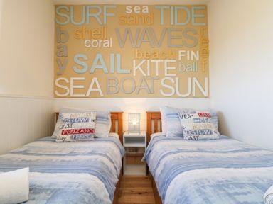 A bedroom with two single beds and a nightstand with a lamp between them in Kerensa ha-Kres Sennen