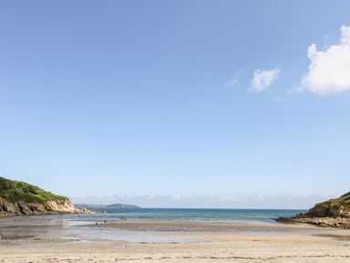 A beach with sand tidal pools rocky headlands and blue ocean at Willow in Falmouth