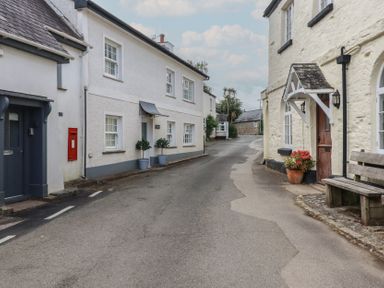 A street with buildings, a post box and a bench at Trelan Mevagissey