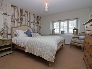 A bedroom with a bed and nightstands at Trelan in Mevagissey