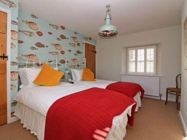 A bedroom with two beds and a fish wallpaper at Trelan in Mevagissey