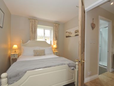 A bedroom with a bed and a window at Stocks Barn in Looe
