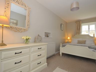 A bedroom with a bed and dresser at Stocks Barn in Looe