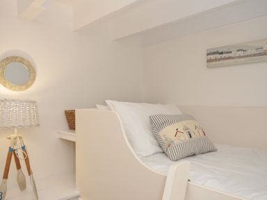 A bedroom with a bed and a lamp at Stocks Barn in Looe