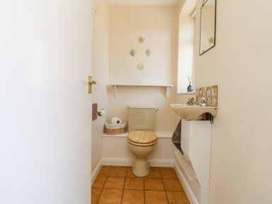 A small bathroom with a toilet and a sink with a mirror above at Charlesworth in Braunton