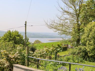 A countryside view with green fields trees and a river in the distance at Charlesworth in Braunton