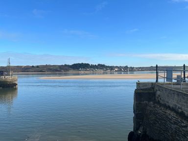 A river with a sandbank and houses in the distance at Sundowner in Padstow