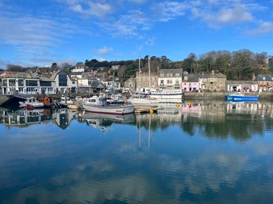 A harbor with boats docked and buildings along the waterfront at Sundowner in Padstow