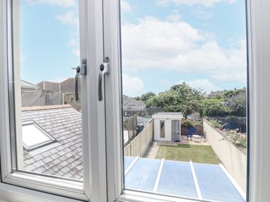 A view from a window showing a garden and shed at Ridgeback House in Mullion
