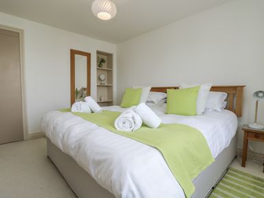 A bedroom with a bed and a mirror at Ridgeback House in Mullion